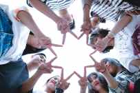 group of people forming star using their hands